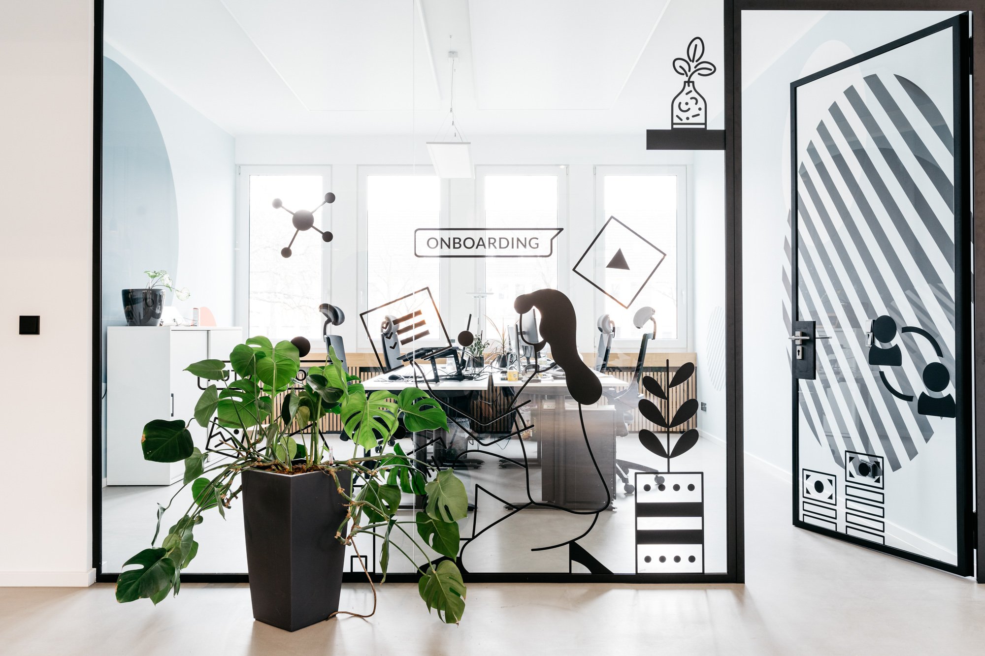 View from outside into a glass office with plants