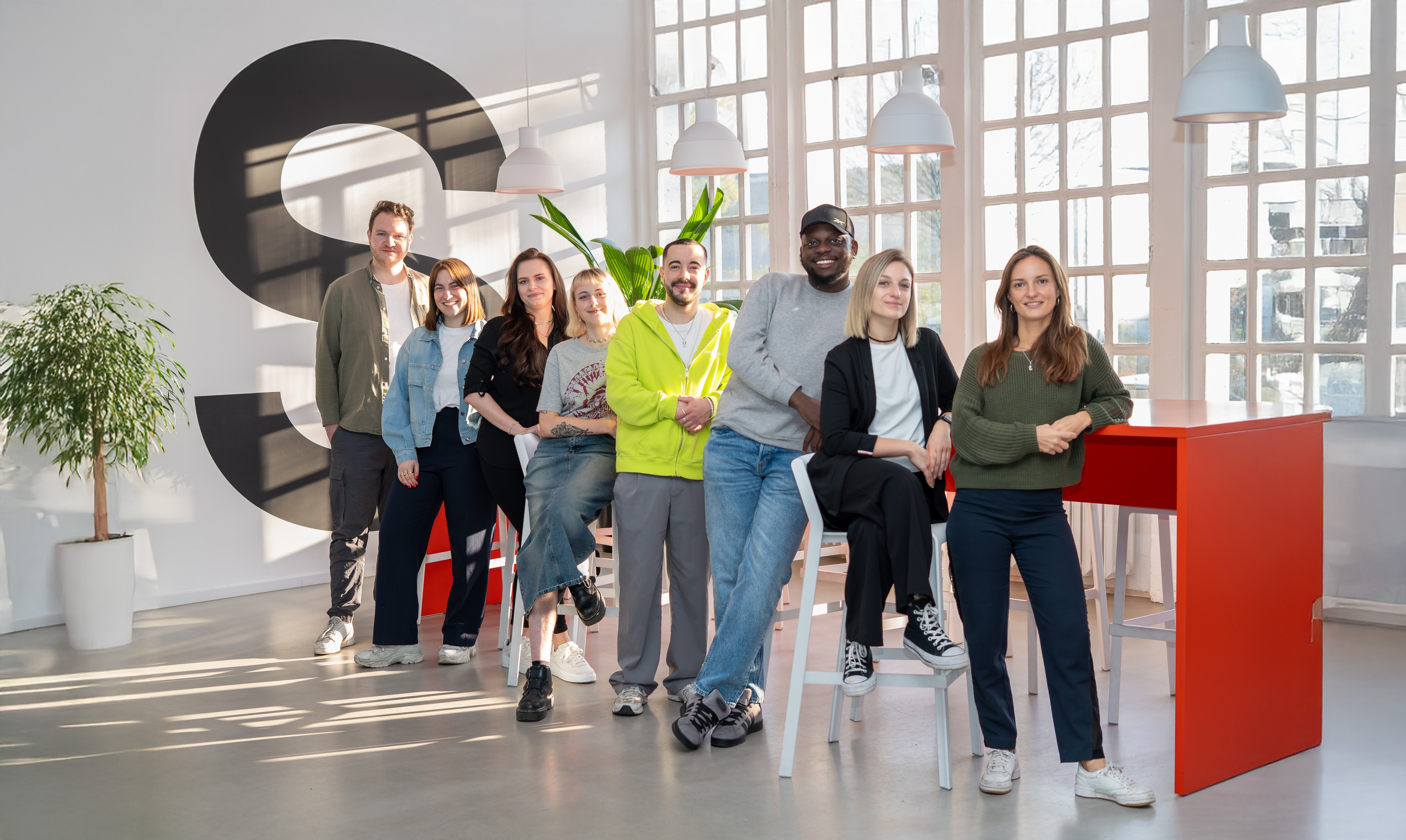 Das Appmatics Team vor einem roten Tisch