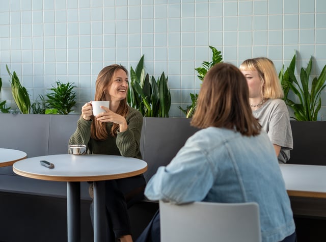Drei Appmatics Mitarbeiterinnen sitzen zusammen an einem Tisch und sprechen über ihre Karriere als Frauen in der IT und Tech Branche